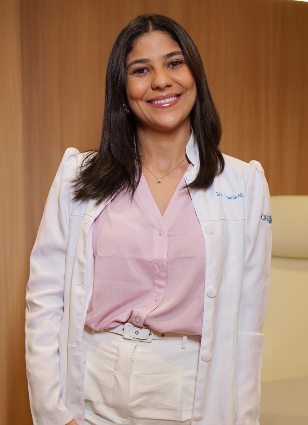 Dra. Camilla Matos, cirurgiã torácica especialista em hiperidrose, de jaleco em seu consultório